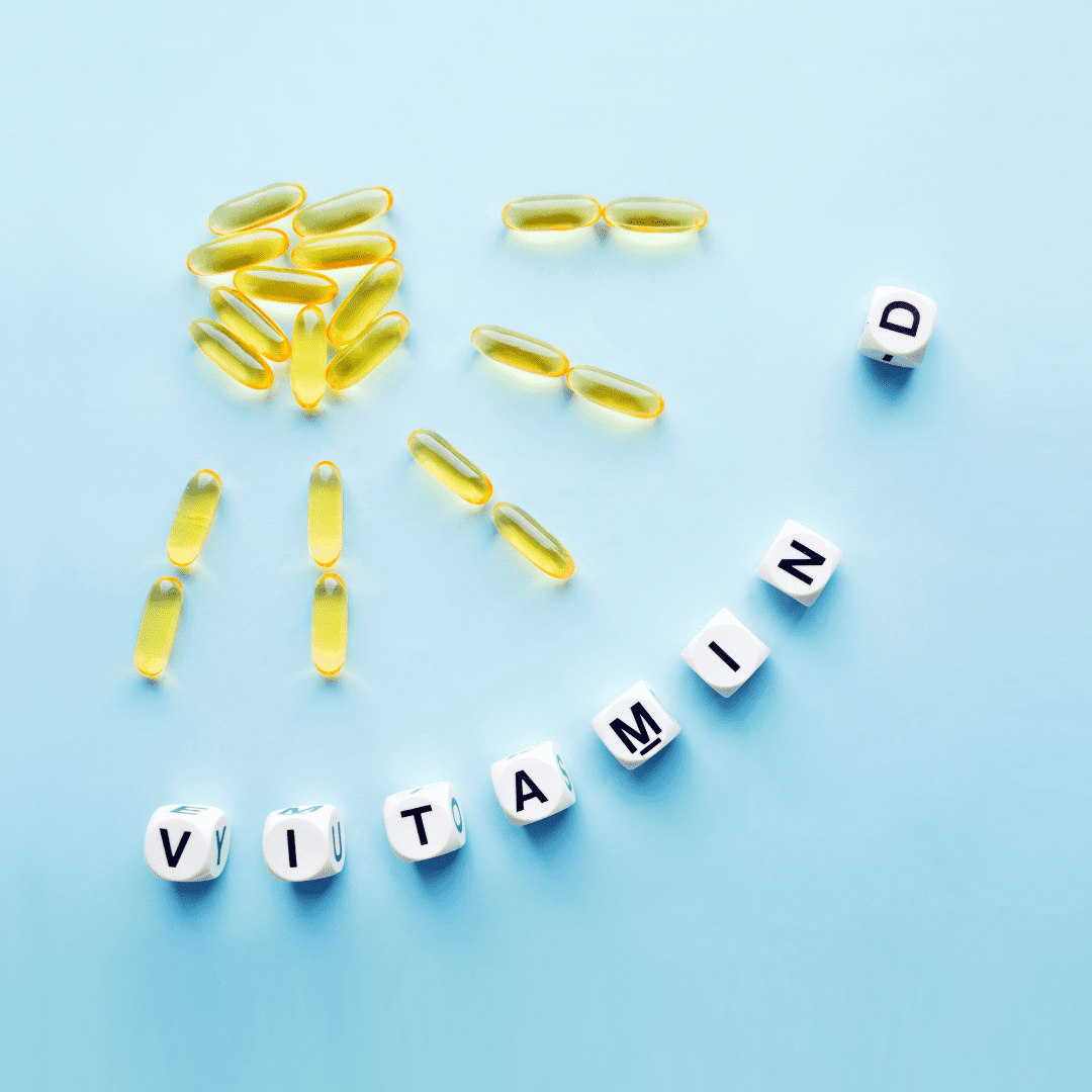 vitamin d supplements laid out like a sun with the words vitamin D beneath it